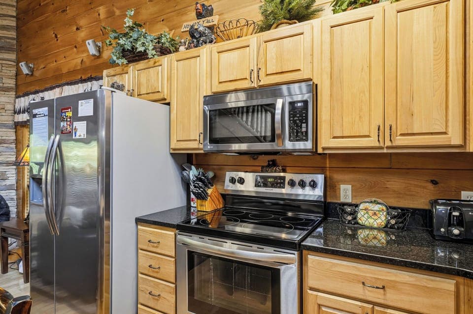 Your fully-equipped mountain kitchen features warm wood cabinetry, granite counters, and stainless steel appliances—perfect for preparing hearty meals.