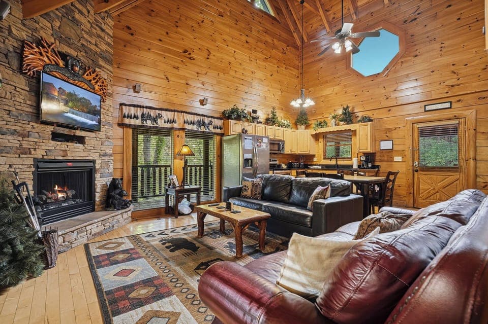 Sink into rich leather sofas by your crackling fireplace, where rustic cabin charm meets modern comfort in this inviting retreat.