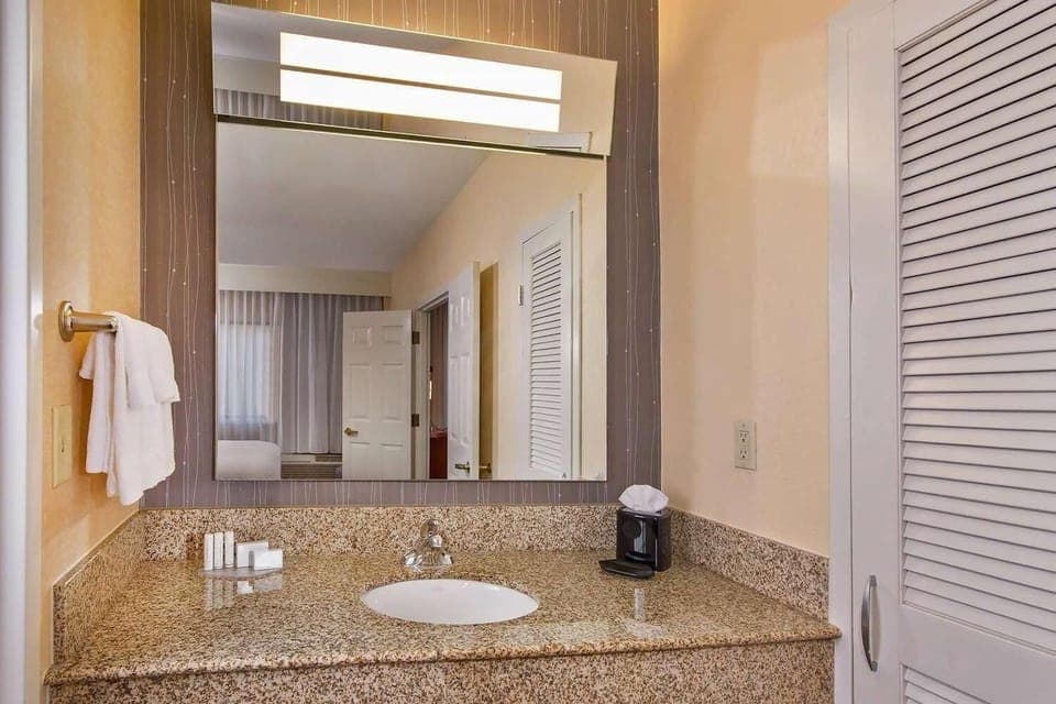 Refresh at a spotless granite vanity with bright mirror lighting.