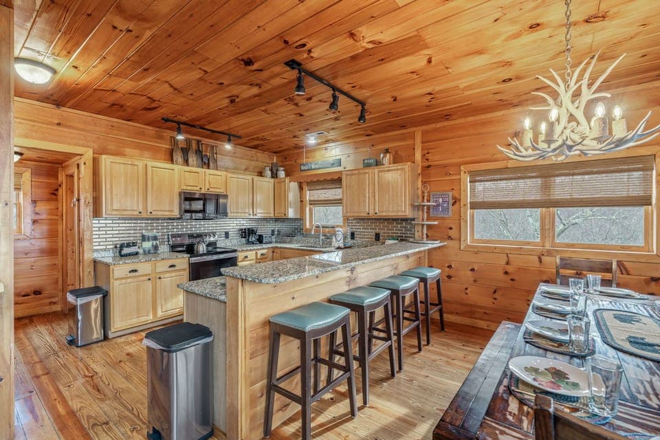Cook memorable meals in this fully equipped kitchen with granite countertops, spacious island seating, and rustic charm throughout your mountain getaway.