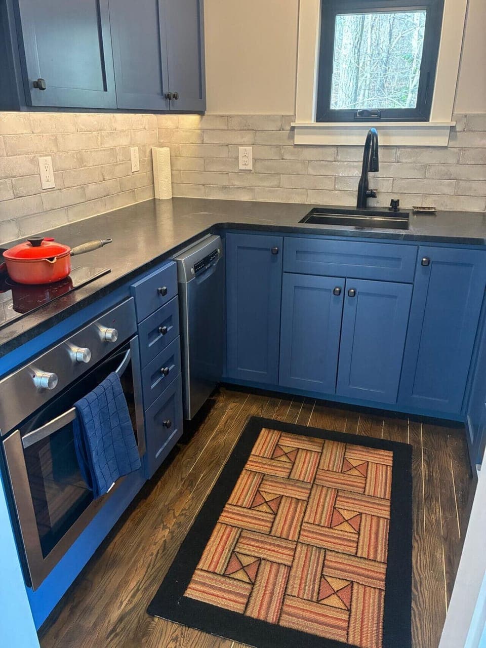 A cozy, modern kitchen that blends rich wood tones with bold blue cabinetry—perfect for everyday cooking and relaxed living.