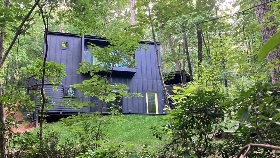 Backyard view highlighting the downstairs entry door for the downstairs unit. The building features two private units, each with its own entrance. Thoughtful insulation ensures a quiet and peaceful stay for both guests.