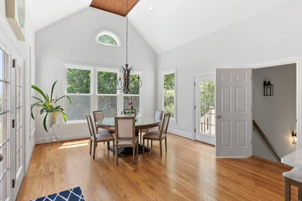 Dining table with seating for 6 off of the kitchen, and a door leading to the outside balcony on the main floor.