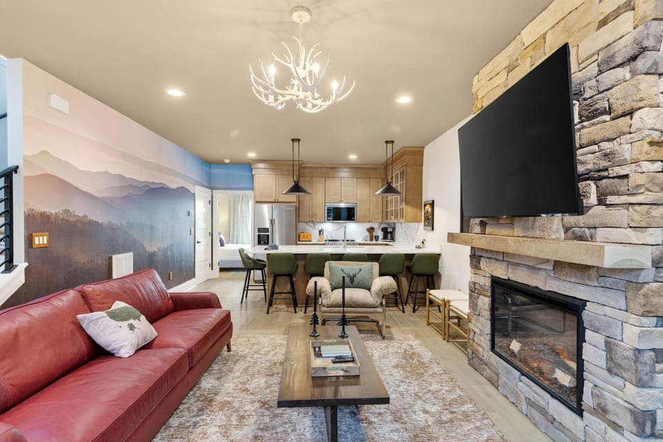 Gather by the stone fireplace—huge TV, cozy seating, and a warm lodge-style vibe. (The Lodge)