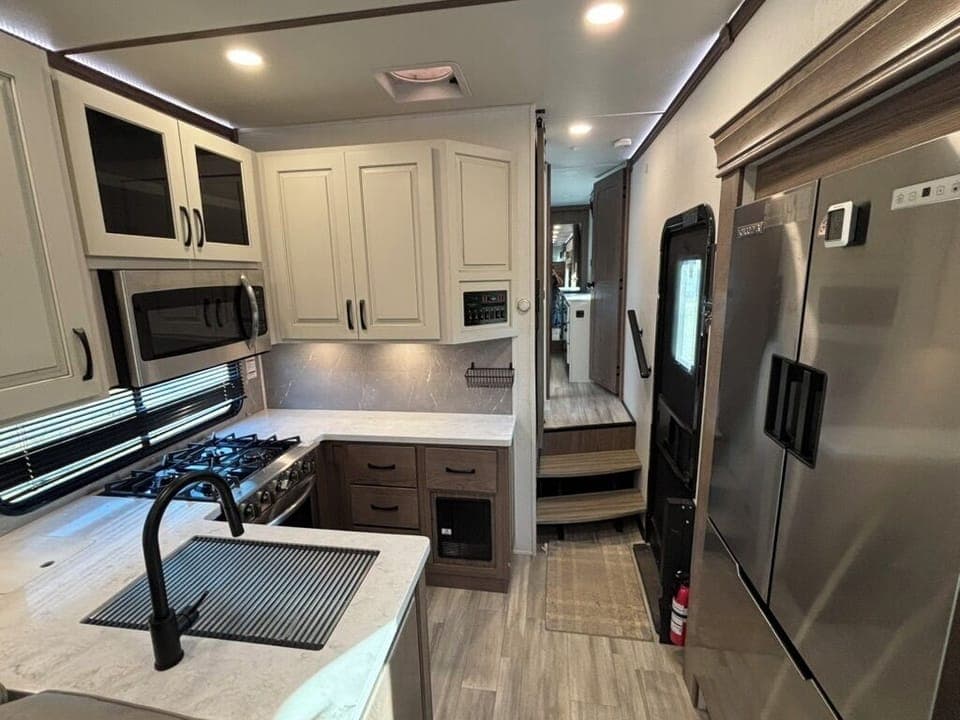 Kitchen with a residential size fridge, four burner stove top and oven