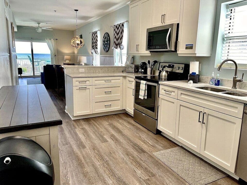 Kitchen with stainless steel appliances and prep island with seating. Oceanview, 102 Isle of Palms, SC | IOP Escapes