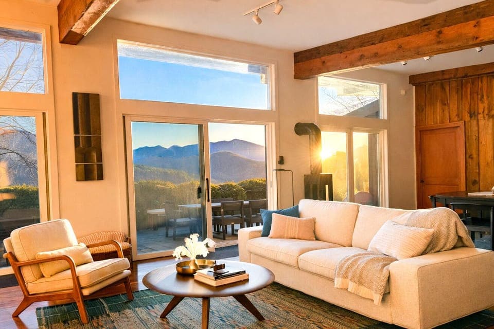 A comfortable sofa with cozy throws next to the gas log stove taking in the view