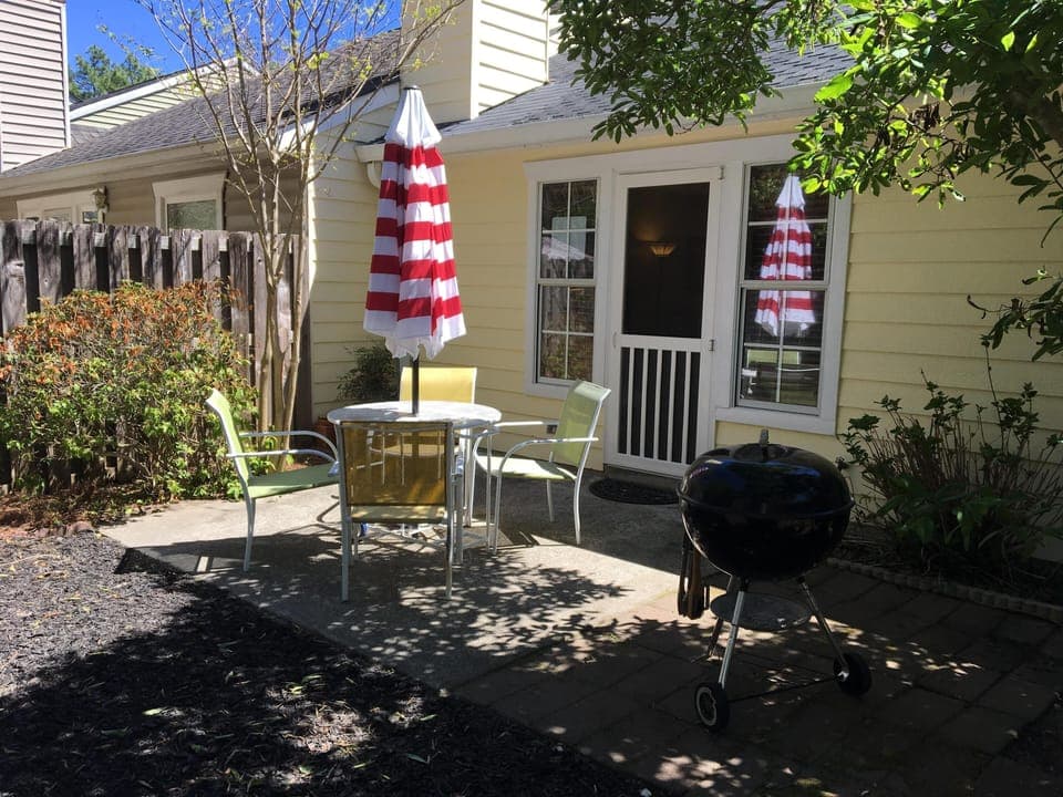fenced back yard with patio and fire pit with additional seating
