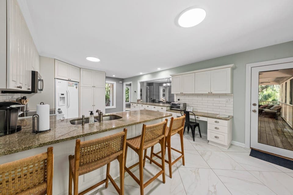 The kitchen counter seats four. The door off the kitchen leads out to the screened porch