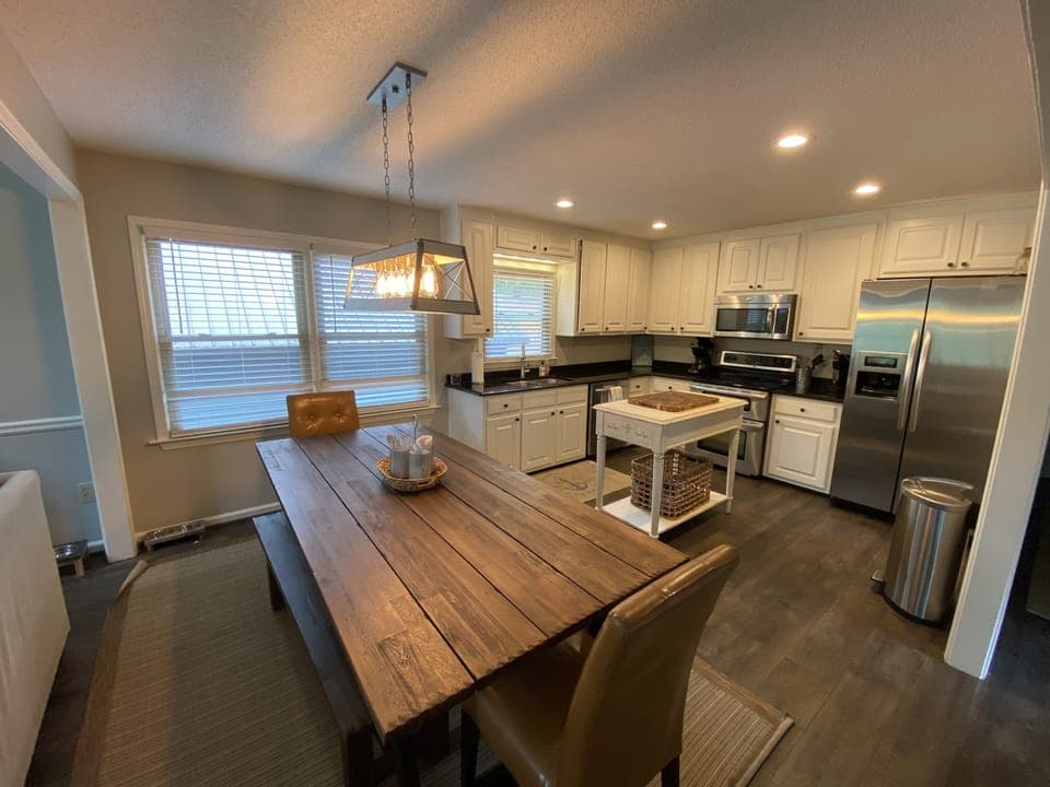 Updated kitchen with LVP flooring, new stainless steel appliances and farm table