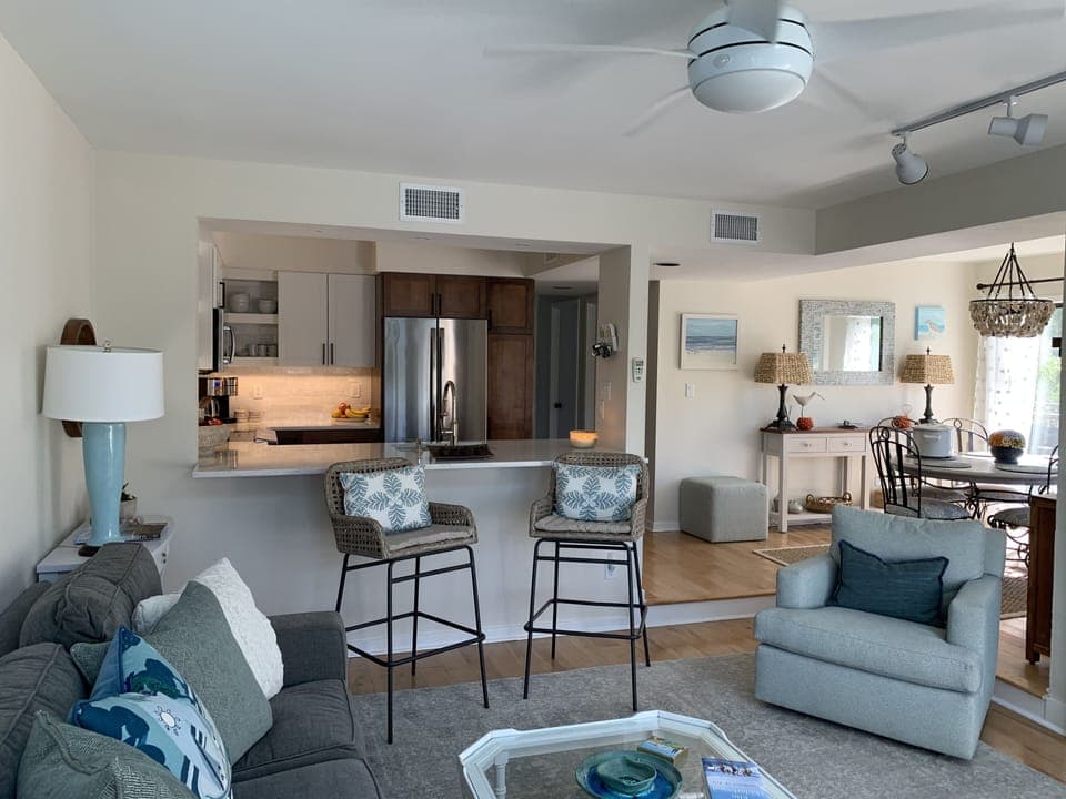 View from living room into newly renovated kitchen, featuring bar seating