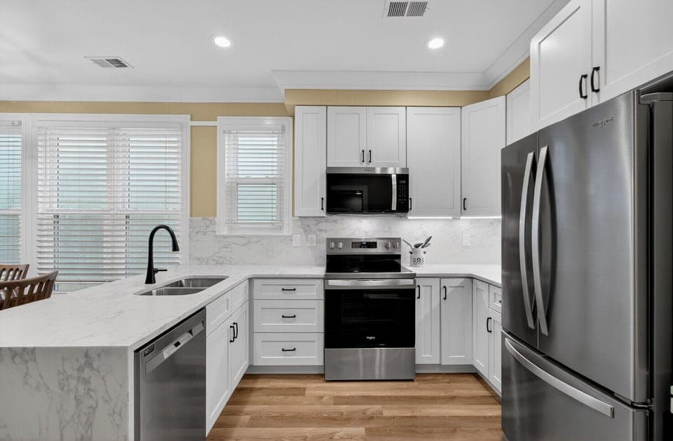 Cook memorable meals in your bright, modern kitchen featuring marble countertops, stainless steel appliances, and abundant natural light.