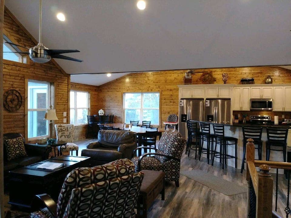 Open livingroom, kitchen, dining area with table, large island and patio seating