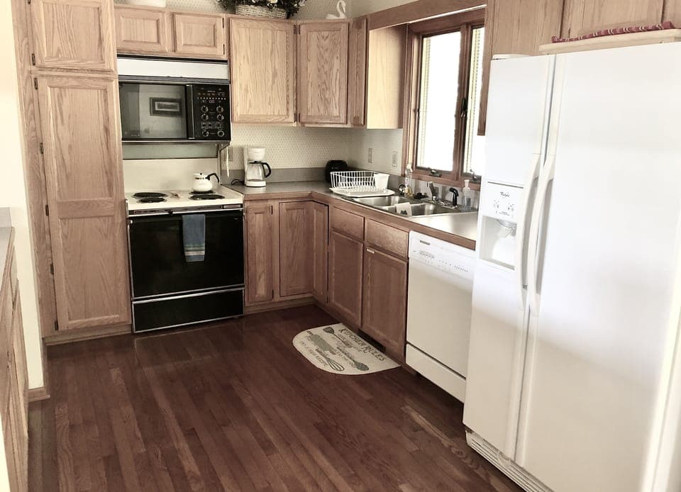 Kitchen equipped with cooking essentials. Empty cabinet space for your groceries