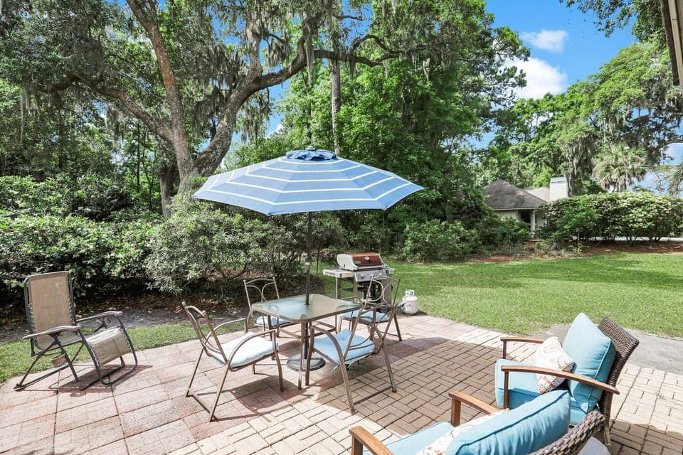 Private patio with outdoor furniture and a gas grill.
