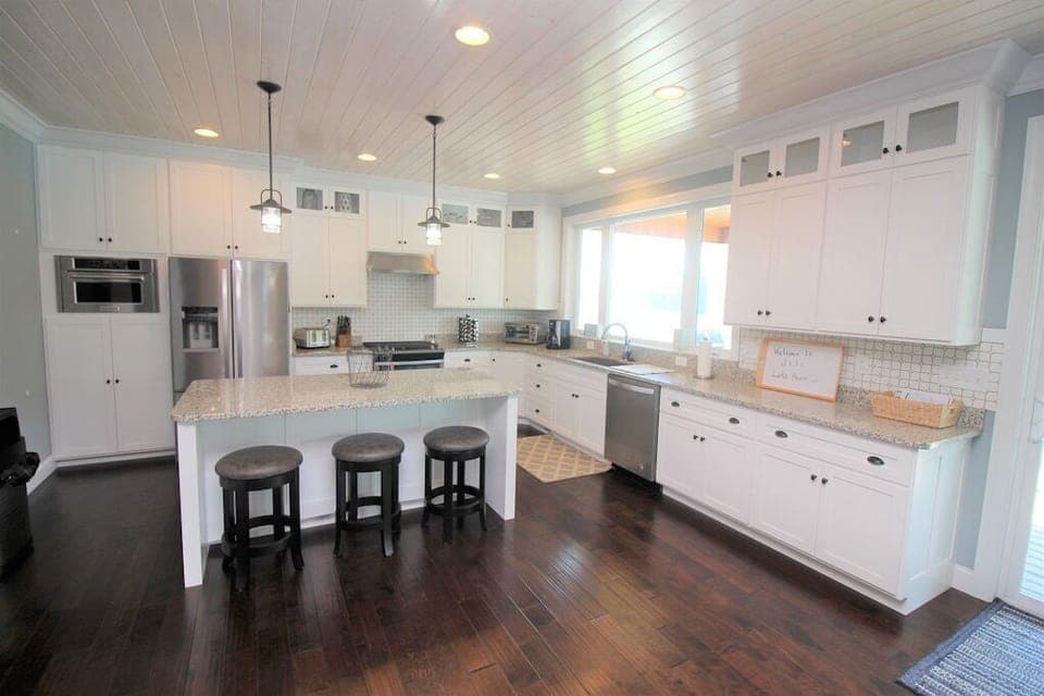 Modern kitchen overlooking the dining room, living room, and the lake.
