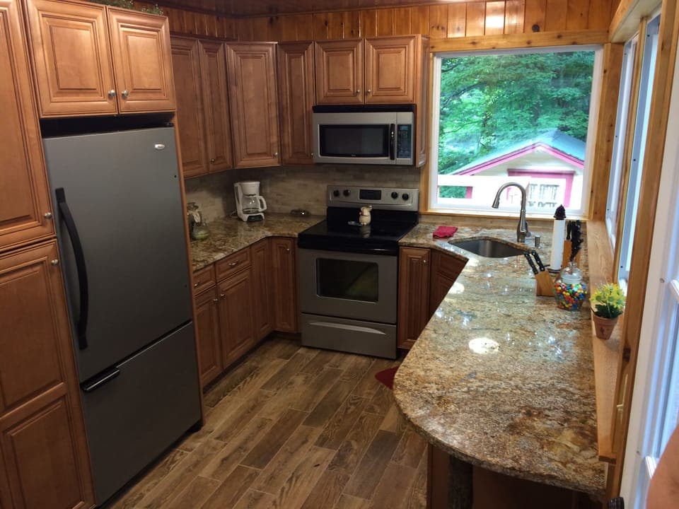 Full Kitchen has picture windows out to screen porch and creek /waterfall views.