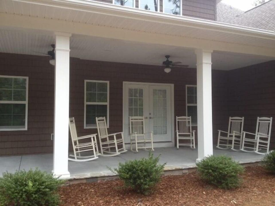 Back porch with rocking chairs and gas grill
