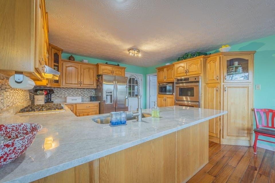 Kitchen with 5 burner stovetop and double ovens. 