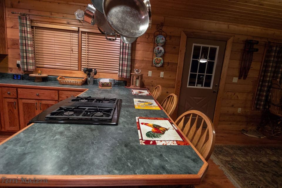 Counter height kitchen bar and a dual fuel Jenn-Air. Gas stovetop, electric oven