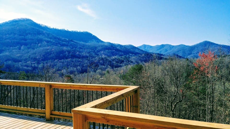 Covered deck has wrought iron/wicker furniture for relaxing or enjoying a meal