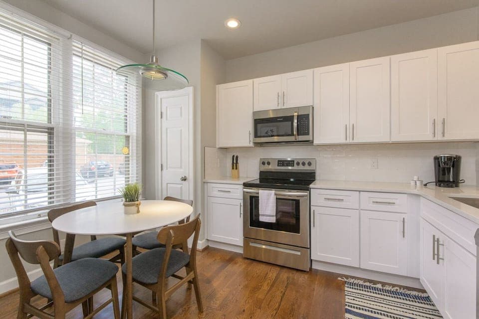 The kitchen also hosts a small table for meals and a pantry closet