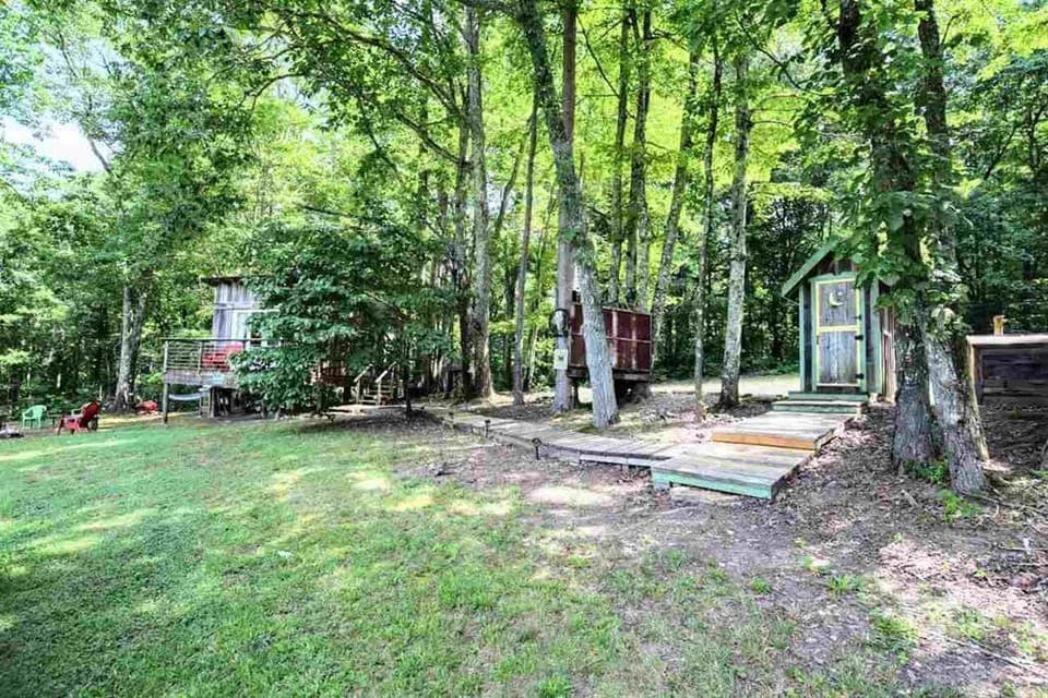 Outdoor shower and outhouse are adjacent  to the cabin.  