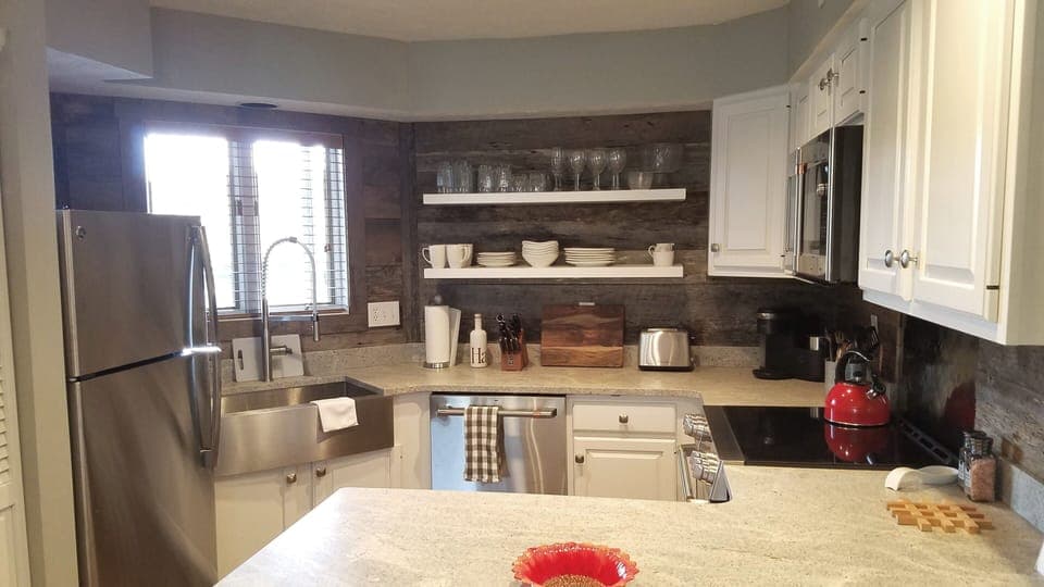 The kitchen has all new stainless steel appliances and floating shelves.