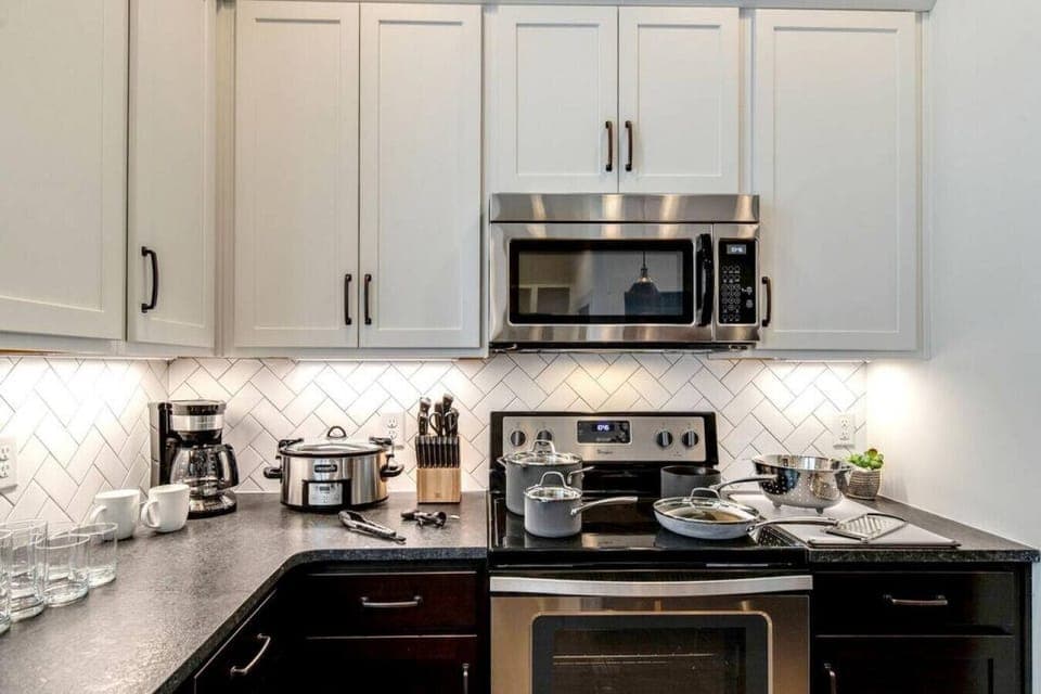 Fully equipped kitchen with stainless steel appliances, drip coffee makers, and kitchen island with additional seating