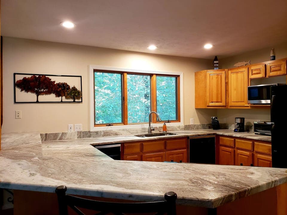 Fully equipped kitchen with fridge, range, dishwasher, microwave, and Keurig.
