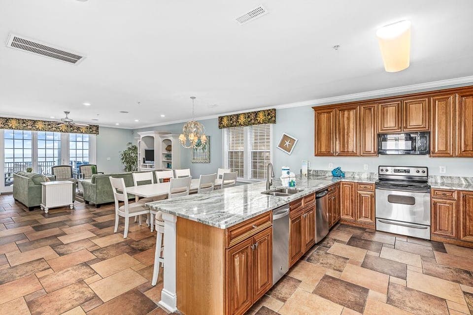 Your spacious kitchen island becomes the heart of gathering, with gleaming granite counters and ocean views creating perfect moments for cooking and conversation.