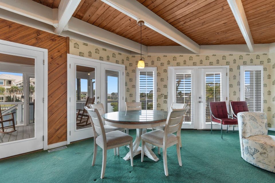 Gather around your dining table beneath stunning exposed beams, where French doors open to invite coastal breezes into your charming retreat.