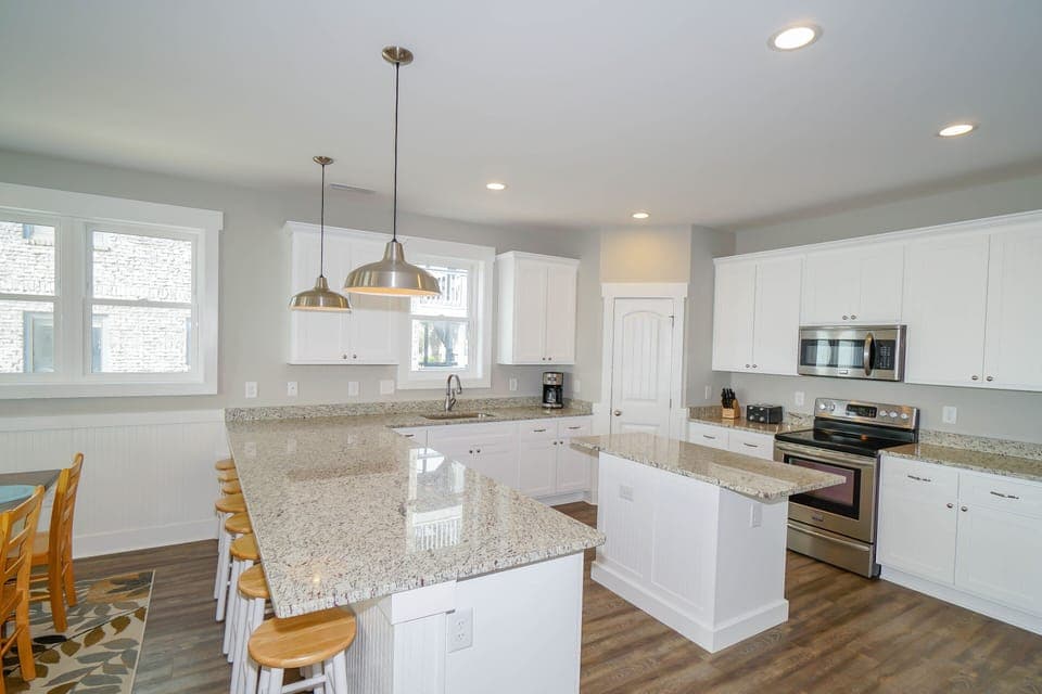 Your bright kitchen features granite countertops, modern appliances, and a spacious island perfect for cooking memorable meals during your stay.