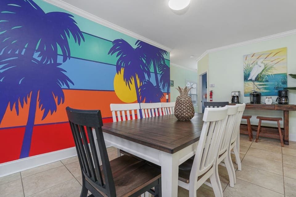 Gather around your tropical dining table beneath vibrant sunset murals that bring island paradise indoors.