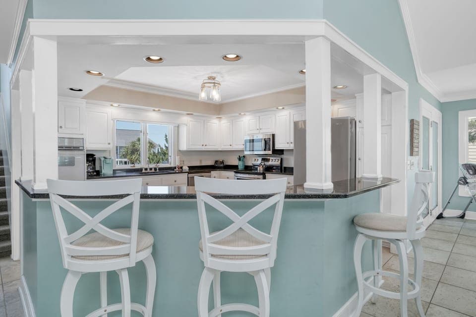 Your dream kitchen awaits with elegant white cabinetry and soothing coastal colors, perfect for preparing memorable vacation meals.