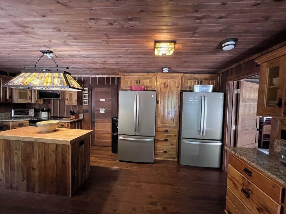 Kitchen with a breakfast bar for guests and two large refrigerators.