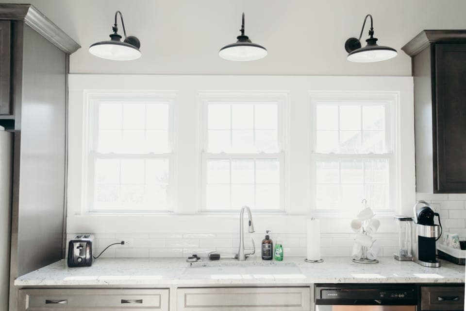 Large counter and sink overlooking fenced in back yard. 