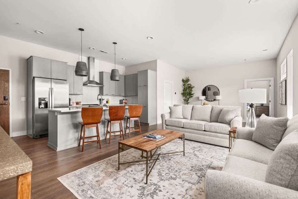 Open-concept living area with abundant natural light, a modern kitchen with island seating, and cozy, stylish furnishings throughout.