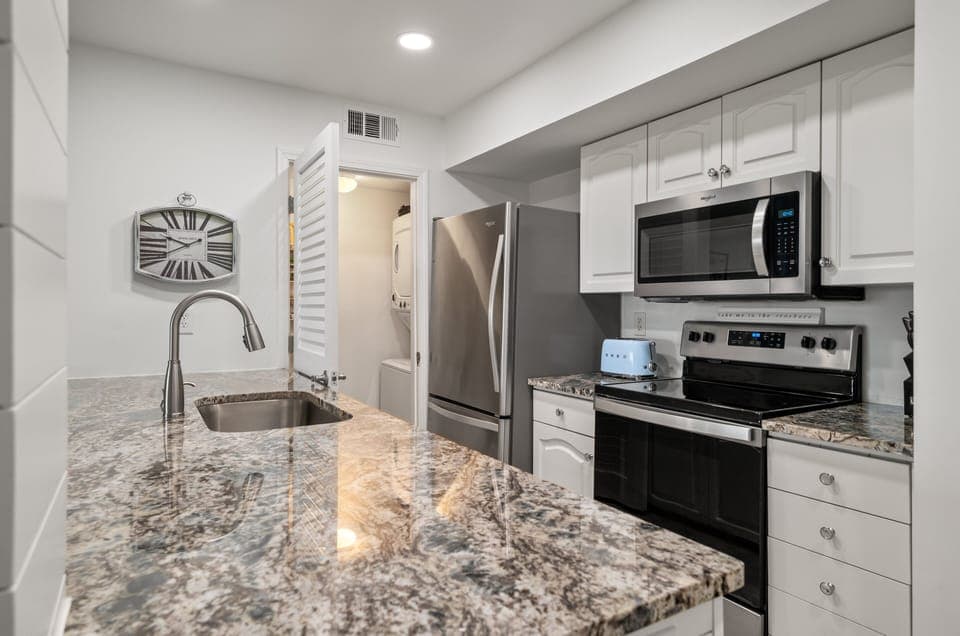 The utility/laundry closet sits off the kitchen and has a stacked washer dryer combo.