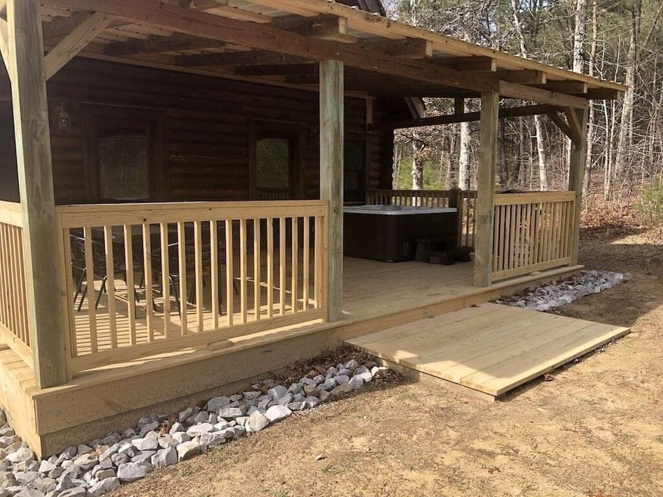 Large back deck with hot tub, grill and seating.
