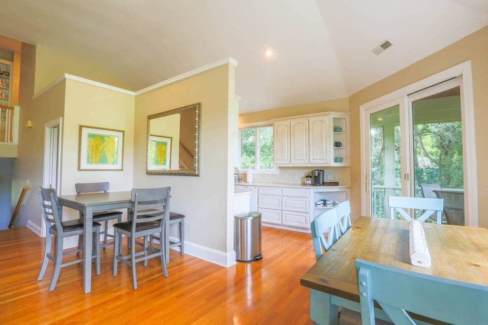 The home features three dining tables -- two indoors and one outdoors on the screened porch.