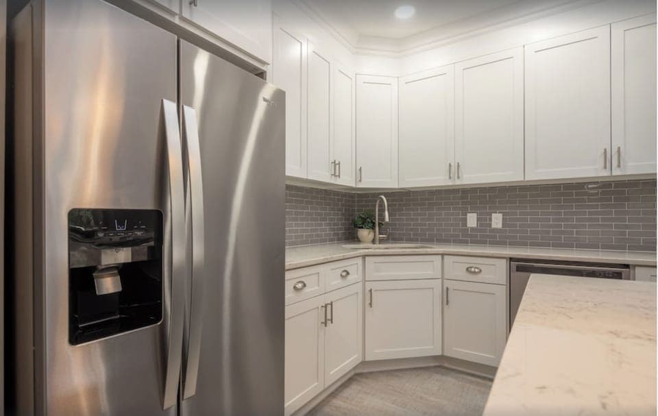 Updated kitchen with custom wood cabinets and stainless steel appliances.