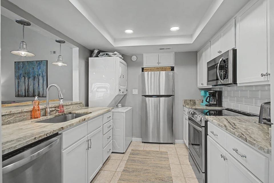 You'll love preparing meals in this stunning modern kitchen with granite countertops, stainless steel appliances, and elegant pendant lighting.