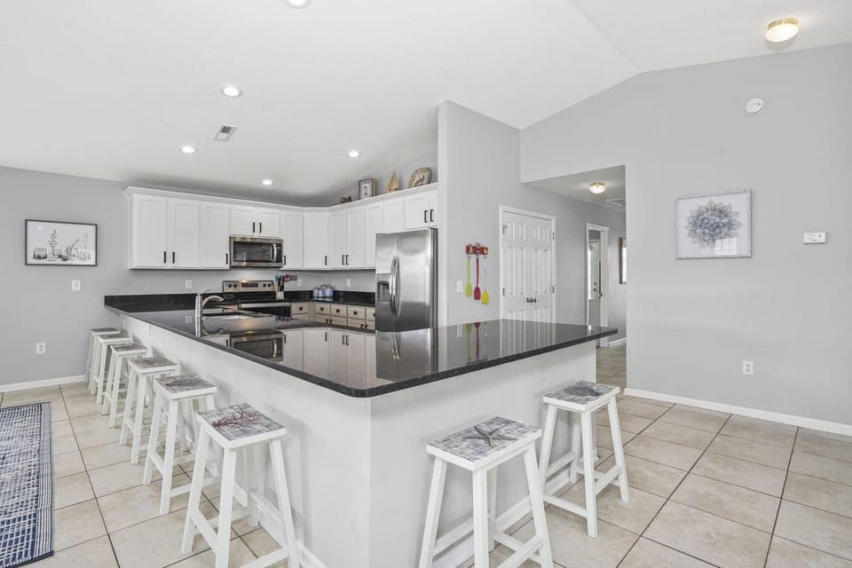 Your spacious kitchen features sleek granite countertops, stainless steel appliances, and a large island with bar seating perfect for group meals and conversations.