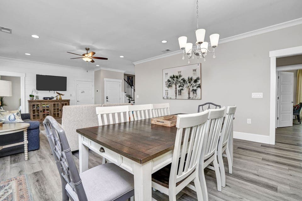 Gather around this spacious dining table where your group can share memorable meals under elegant chandelier lighting.