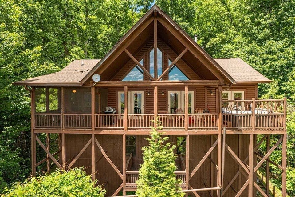 View of the cabin's large back deck surrounded by trees. Perfect for morning coffee in Bryson City, NC with peace, privacy, and wooded scenery.