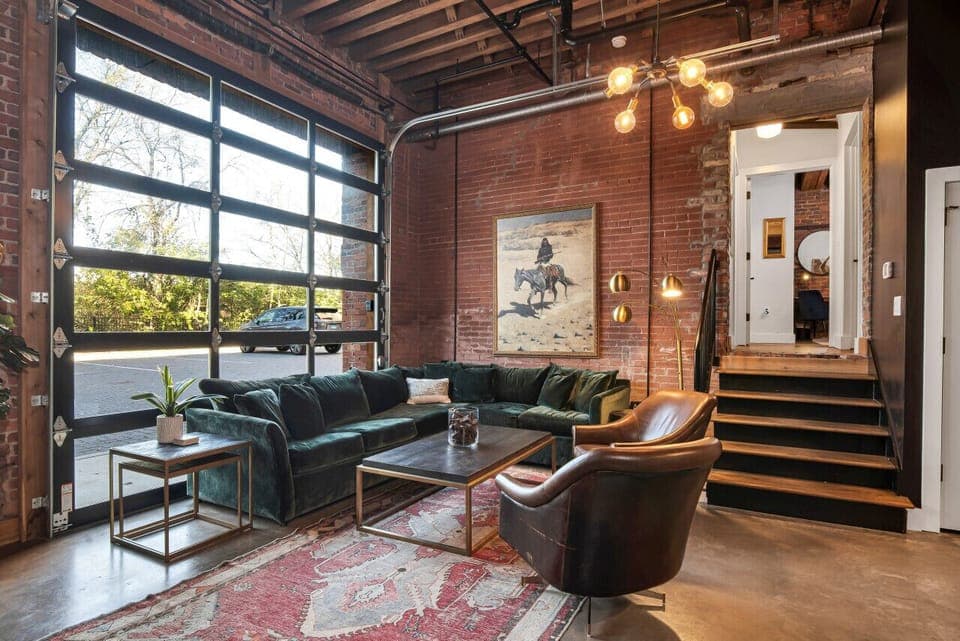 Spacious living room with large couch that turns into sleeper sofa. Unique glass garage door! Plus a 65` smart TV with Sonos! This condo has its own private entrance.