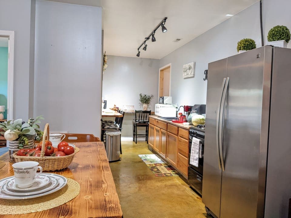 View thru the kitchenette with microwave sink stove/oven & refrigerator/freezer.