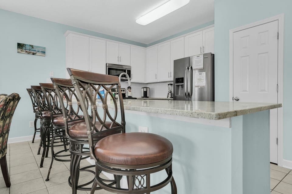 Gather around this elegant kitchen island for morning coffee or casual meals, featuring stylish bar seating and modern appliances.