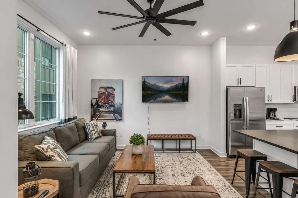 Modern living room with bright ambiance, comfy seats, and a Smart TV.